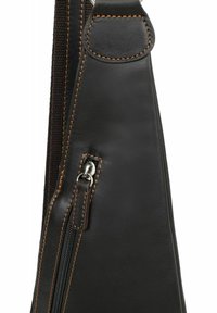 Borsa nera in pelle con una superficie texture, caratterizzata da cuciture marroni a contrasto, una tasca con zip e una tracolla liscia con un'estremità arrotondata.
