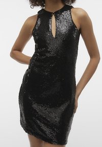 Schwarzes Pailletten-Kleid mit figurbetonter Silhouette, ärmellosem Design und einem Schlüssel-ausschnitt. Glatte Textur mit glänzenden Pailletten-Details.