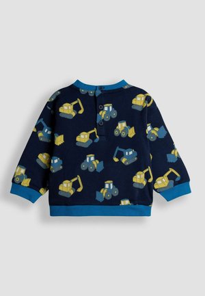 Mornariće plava dukserica dugih rukava s uzorcima žutih građevinskih vozila, koja ima plavi rebrasti ovratnik i dugmad na leđima.