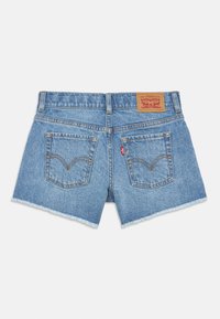 Τζιν σορτσάκι σε ανοιχτό μπλε χρώμα με ξεφτισμένο τελείωμα, δύο πίσω τσέπες και δερμάτινη ετικέτα στη μέση με το λογότυπο της μάρκας.