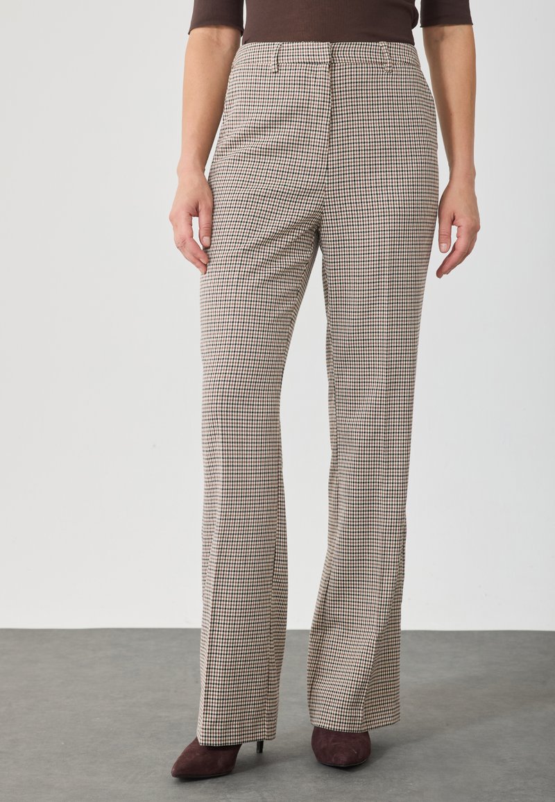 Pantalons à taille haute en plaid beige et marron avec une coupe évasée, fabriqués en tissu texturé, comportant des poches latérales et des plis repassés.