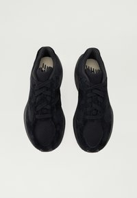 Adidași sport negri, confecționați dintr-un amestec de materiale din suede și plasă, cu o formă rotundă, limbă căptușită și șireți plata pentru o fixare sigură.