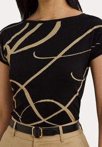 Czarny t-shirt z złotymi abstrakcyjnymi wzorami, z szerokim dekoltem w łódkę i krótkimi rękawami, wykonany z miękkiego materiału. W połączeniu z czarnym paskiem.