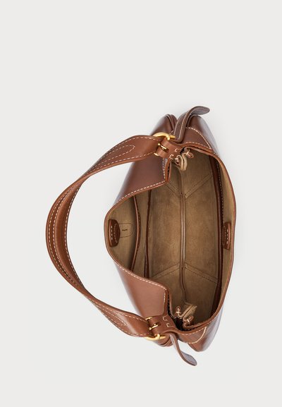 Rudas odinė rankinė su lygiu paviršiumi, suapvalinta forma ir detaliu siuvinėjimu. Yra viena juosta ir erdvus, nepaklijuotas vidus.