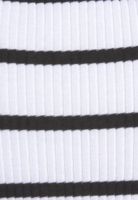 Tissu en maille côtelée présentant des rayures horizontales alternées en blanc et noir. La texture semble douce avec un léger éclat à la surface.