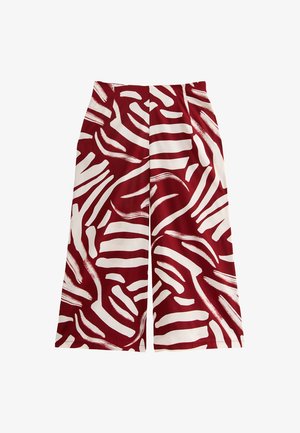 Pantalons à jambes larges en rouge profond et blanc avec des motifs de coups de pinceau abstraits. Fabriqués en tissu léger avec une texture lisse. Design taille haute.