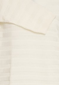 Tissu en maille blanche avec des rayures horizontales alternées en mailles pleines et ouvertes, et un bord à revers plié.