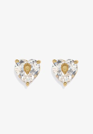 Pair of heart-shaped clear crystal stud earrings with central gold seashell detail, held by three gold prongs each.