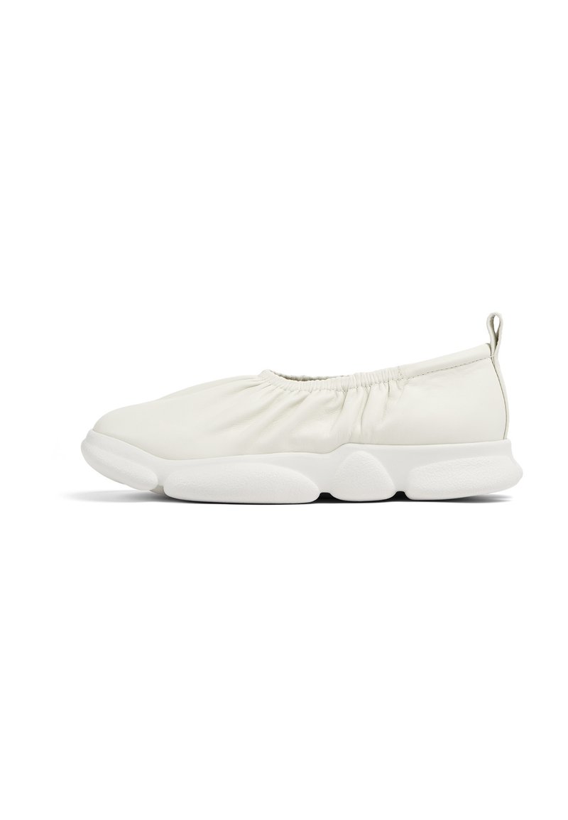 Scarpe slip-on bianche con una tomaia morbida e testurizzata e arricciatura elastica all'apertura; suola bianca spessa e imbottita.