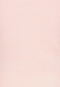 Ribbet pink stof med en blød glans. Teksturen har vertikale linjer, der skaber et subtilt mønster på overfladen.