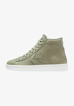 Baskets montantes en daim vert avec texture perforée, semelle en caoutchouc blanche et logo étoile en accent sur le côté. Lacées avec des lacets verts assortis.