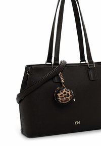 Black leather tote bag featuring dual handles, a removable round leopard print charm, and a subtle embossed logo on the front.