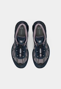 Zapatillas deportivas ligeras de color marinero con paneles de malla, acentos reflectantes y una suela texturizada. Cuenta con un sistema de cordones para un ajuste ajustable.