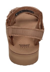 Sandalias Teva marrones con un superior texturizado y suave, y correas ajustables. Suela gruesa con un sutil logotipo, diseñadas para comodidad y estabilidad.