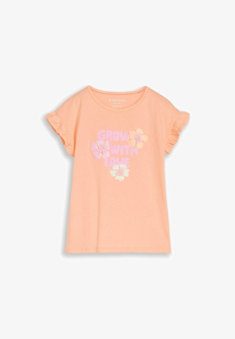 Chemise à manches courtes couleur pêche avec des manches à volants et une impression disant « Grandir avec amour » entourée de trois fleurs aux couleurs pastel.