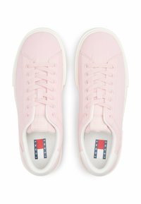Baskets rose clair avec une surface lisse, lacets blancs et semelle extérieure blanche. Comprend une étiquette logo en rouge, blanc et bleu sur les semelles intérieures.