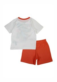 T-shirt blanche à manches courtes avec un col rond orange, associée à un short orange. Les deux sont en tissu doux avec un design décontracté.