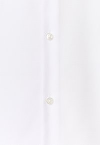 Camicia bianca con bottoni, caratterizzata da un tessuto strutturato con un motivo sottile, tre bottoni visibili lungo la patta e collo standard.