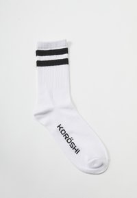 Calcetín atlético blanco con dos franjas horizontales negras en la parte superior y el nombre de la marca "KORÖSHI" en negro en el costado. Material de mezcla de algodón.