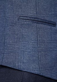 Granatowa tkanina w kratę o subtelnej fakturze; ma jedną kieszeń na piersi oraz wyraźnie zarysowane klapy dla eleganckiego wyglądu.