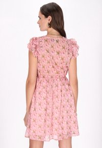 Floral pinkes Kleid mit Rüschensleeves, aus einem transparenten, leichten Stoff und mit elastischem Bund. Das Muster besteht aus rosenähnlichen Blüten.