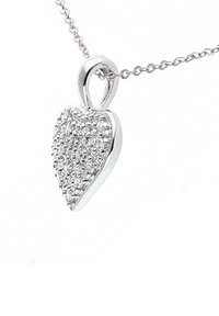 Ciondolo a forma di cuore in argento con una superficie texturizzata, caratterizzato da piccole pietre scintillanti. Attaccato a una delicata collana in argento.