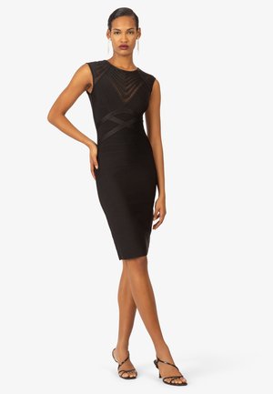 Schwarzes ärmelloses Kleid mit strukturiertem Oberteil, taillierter Silhouette und knielanger Saumlänge. Mit horizontalen und vertikalen Designlinien.