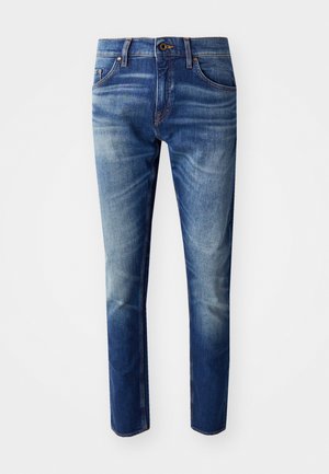 Jeans slim fit realizate din denim, într-o nuanță de albastru mediu până închis. Dispune de cinci buzunare, o închidere cu buton și o ușoară decolorare pe coapse.