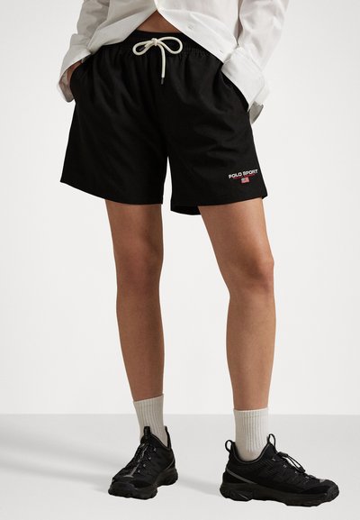 Schwarze Badeshorts mit elastischem Bund und weißem Kordelzug. Mit rotem "POLO SPORT" Logo auf der linken Seite. Strukturierter Stoff.