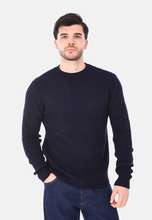 Maglione lavorato a maglia blu navy con scollo rotondo e texture a coste. Maniche lunghe e vestibilità comoda, abbinato a jeans in denim.