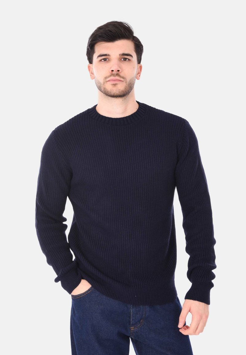 Maglione lavorato a maglia blu navy con scollo rotondo e texture a coste. Maniche lunghe e vestibilità comoda, abbinato a jeans in denim.