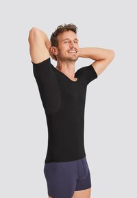 Black short-sleeve t-shirt made of stretch fabric, featuring a round neckline and seamless shoulders. Worn with navy blue boxer shorts.