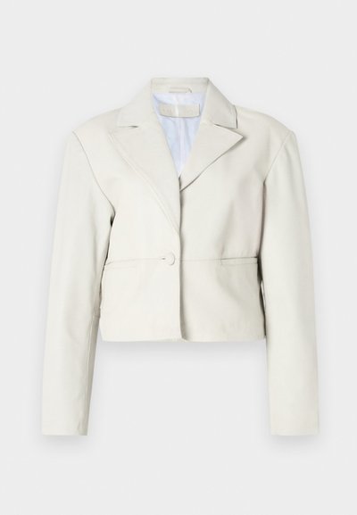 Κομμένο μπεζ μπουφάν με κουμπί, φαρδιές πέτες και μακριά μανίκια. Λείος υφαμένος με απλή, μινιμαλιστική σχεδίαση.