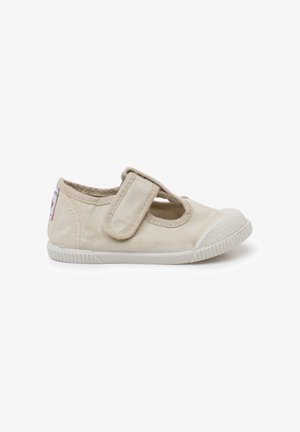 Scarpa beige per bambino con suola in gomma e puntale, dotata di una larga fascia in Velcro sulla parte superiore per una facile chiusura e regolazione.