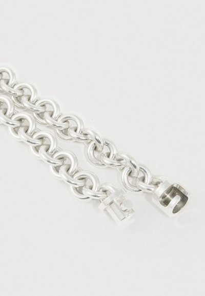 Armbånd i sølvmetal med sammenkædede runde led og en lås med hexagonalt design og et lille pinnedetalje.