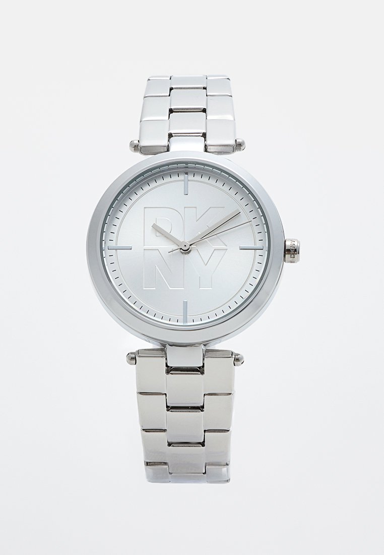 Montre en acier inoxydable argenté avec un cadran rond, logo DKNY en relief et marqueurs d'heure gris simples. Design de bracelet à maillons en métal.