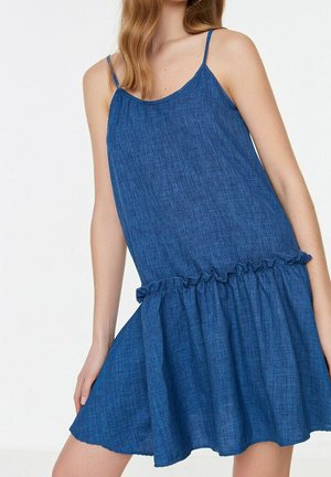 Denimjurk met een mouwloos ontwerp, blauw chambray-stof, een uitlopende rok en een gerimpelde afwerking bij de taille voor extra detail.