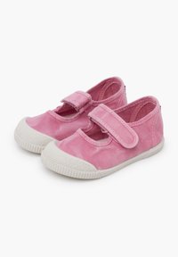 Růžové plátěné boty s kulatou špičkou, bílou gumovou podrážkou a suchým zipem pro zapínání. Disponují výřezovým designem po stranách.