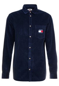 Navy blauwe corduroy overhemd met lange mouwen, button-down kraag, voorzak met een logo patch en beige knopen.