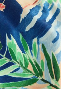 Tissu avec un motif floral abstrait coloré, comprenant des feuilles vertes et des formes bleues, pêche et bleu clair sur un matériau texturé.
