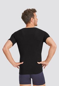 Black short-sleeve t-shirt with a round neck, made of smooth fabric, featuring a fitted design and seamless back detailing.