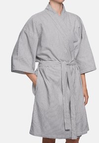 Kokvilnas peldmētis melnbaltās svītrās, līdz ceļiem, ar platām piedurknēm, jostu viduklī un divām sānu kabatām.