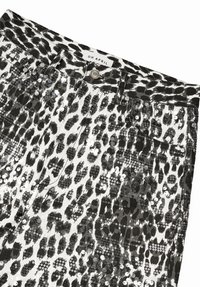 Mustavalkoiset paljetein koristellut housut, joissa on leopardikuvio. Kangas on kiiltävä ja hohtava, ja housuissa on tavalliset taskut sekä napillinen kiinnitys.