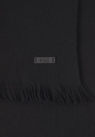 Écharpe noire en tricot avec des bords à franges et une forme rectangulaire. Une petite étiquette "BOSS" en relief est cousue sur le tissu.