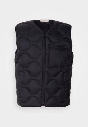 Crna podstavljena prsluk s okruglim prošivenim uzorkom, prednjim patentnim zatvaračem i malim džepom na lijevoj strani. Izrađen od lagano podstavljene tkanine.