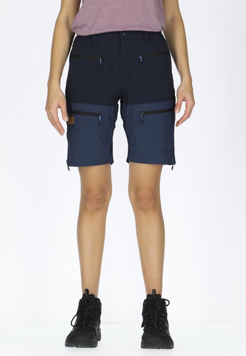 Pantaloni shorts blu navy con una finitura texturizzata, caratterizzati da multiple tasche con zip, inserti scuri a contrasto e un design resistente.