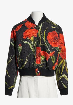 Chaqueta bomber negra con estampado floral rojo, cuello, puños y dobladillo acanalados, exhibida en un torso de maniquí blanco.