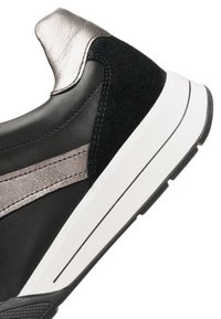 Black sneaker with textured suede and smooth leather, featuring metallic silver accents and a thick white sole with black rubber tread.