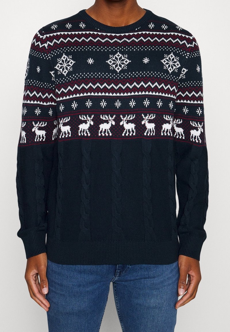 Mörkblå stickad tröja med vita och vinröda vintermönster, inklusive snöflingor och renar, med kabelstickad textur.