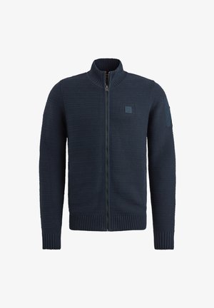 Marineblauer Reißverschluss-Pullover mit hohem Kragen, gerippten Bündchen und Saum, strukturiertem Strickmuster und einem Patch-Detail am linken Ärmel.